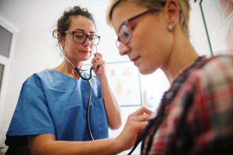 outpatient nurse using stethoscope with patient
